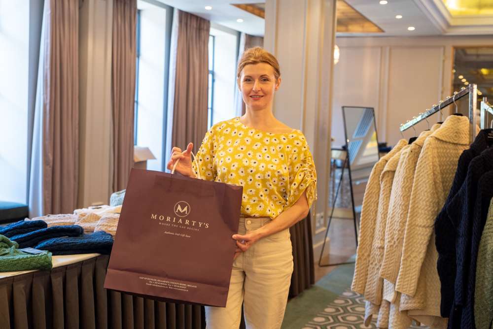 Staff member Sonia holding Moriarty’s branded shopping bag at a corporate gifting event